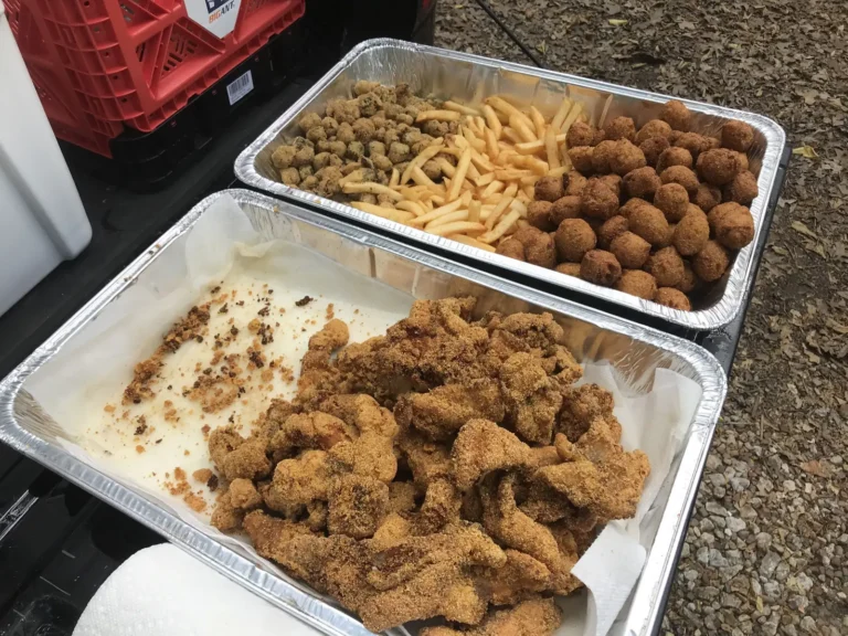 Pans of Southern fried catfish with fries, hushpuppies and fried okra